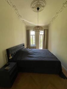 Schlafzimmer mit einem großen Bett mit blauer Tagesdecke in der Unterkunft Ruhige&charmante Altbauwohnung in Leipzig