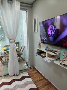 a living room with a large flat screen tv on a wall at Casa Linda e Aconchegante in Manaus
