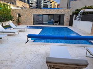 een zwembad met een blauwe buis in een gebouw bij VILLA ENJOY LUX private heated pool in Split in Split
