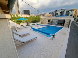 een zwembad met ligstoelen en een zwembad bij VILLA ENJOY LUX private heated pool in Split in Split