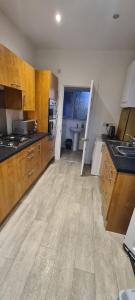 a large kitchen with wooden cabinets and a sink at Sheffield City Suites in Manor