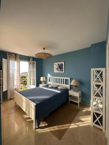 ein Schlafzimmer mit einem Bett und einer blauen Wand in der Unterkunft VILLA SIERRA CORTINA VISTAS AL MAR in Alicante