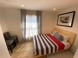 um pequeno quarto com uma cama e uma janela em Bright modern new coastal home with inspiring details in Santa Monica em Los Angeles