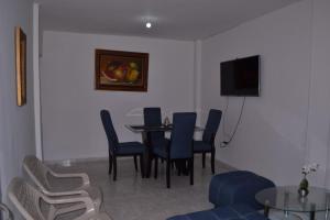 a dining room with a table and chairs and a television at Casa para Vacaciones Riohacha in Ríohacha