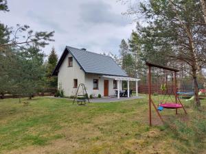 a small house with a playground in front of it at Domek u Beti in Wąglikowice