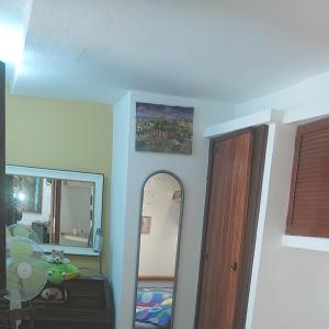 una stanza con specchio e un corridoio con porta di Casa dell'Artista singola indipendente a Cagliari