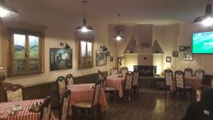 a dining room with tables and chairs and a flat screen tv at Hotel Lido in Prishtinë