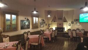 comedor con mesas y sillas y TV de pantalla plana en Hotel Lido, en Pristina