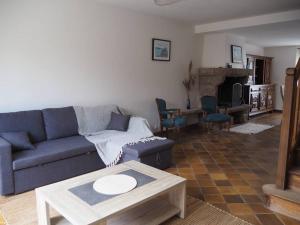 un soggiorno con divano blu e tavolo di Gîte Location des 4 saisons a Bacilly