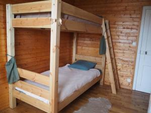 a wooden bunk bed in a log cabin at Gîte Location des 4 saisons in Bacilly