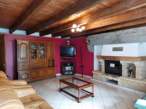 a living room with a couch and a fireplace at maison individuelle au calme sur l'Aubrac in Recoules-dʼAubrac