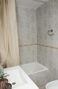een badkamer met een wit bad en een wastafel bij Sunshine Apartment Fuengirola in Fuengirola