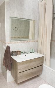 een badkamer met een wastafel, een spiegel en een bad bij Sunshine Apartment Fuengirola in Fuengirola