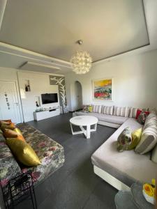 ein Wohnzimmer mit einem Sofa und einem Tisch in der Unterkunft Lilacs Garden Cabo in Mʼdik