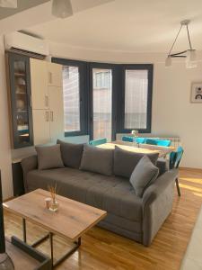 - un salon avec un canapé et une table dans l'établissement La Vita Apartments, à Skopje