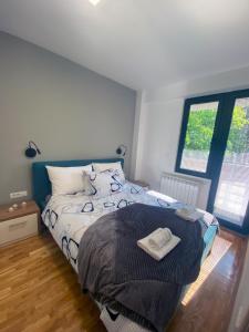 - une chambre avec un lit et une couette bleue et blanche dans l'établissement La Vita Apartments, à Skopje