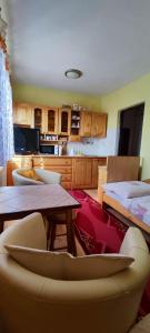 Homestay Machom في أوسكادنيكا: غرفة معيشة مع طاولة ومطبخ