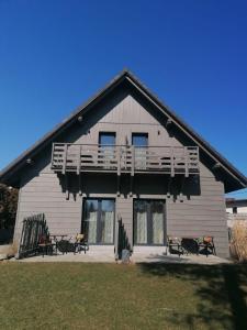 Cette grande maison dispose d'un balcon sur le côté. dans l'établissement Pokoje 64, à Ustroń