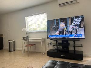 a living room with a flat screen tv on a wall at Miami haven by airport in Miami