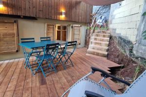Mamoudzou的住宿－Appartement les petits Baobabs 2，木制甲板上的蓝色桌子和椅子