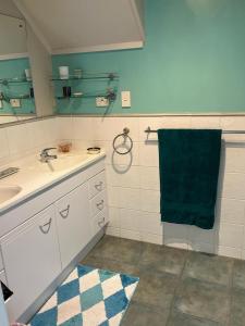 a bathroom with a sink and a green towel at Red Beach Retreat in Red Beach