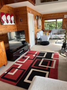 een woonkamer met een televisie en een tapijt bij Red Beach Retreat in Red Beach