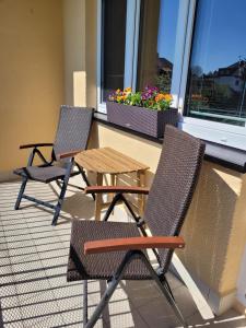 dwa krzesła i drewniany stół na balkonie w obiekcie Nový apartman Eva w Jiczynie