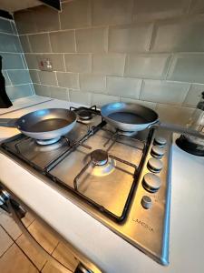 two frying pans sitting on top of a stove at Perfect family home next to London Bridge in London