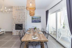 a dining room with a wooden table and chairs at Tilagus holiday villa - Nostromo in Žman