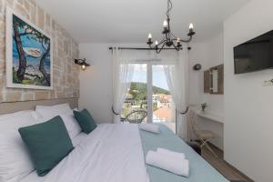 a bedroom with a large white bed with a window at Tilagus holiday villa - Nostromo in Žman