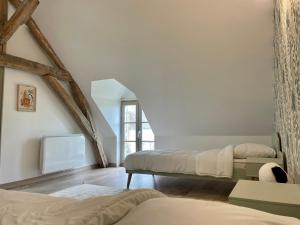 um quarto com 2 camas e uma janela em Le gîte du four à pain em Noyers-sur-Cher