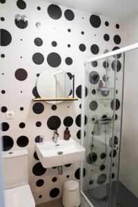a bathroom with black and white polka dots on the wall at Hostal Tarantelo Conil in Conil de la Frontera