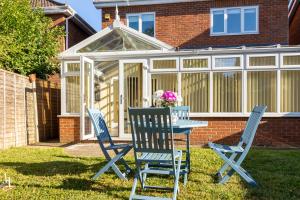 a table and chairs in front of a conservatory at Fair View - Off Street Parking and Garden in Shrewsbury