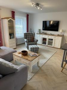 a living room with a couch and a tv at Ferienparadies Bodensee Fewo1 in Owingen