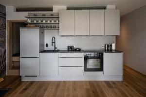 a kitchen with white cabinets and an oven at SeeCondo in Unterburg am Klopeiner See