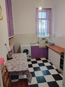a kitchen with purple cabinets and a checkered floor at Комната pilika 4room with shared bath in Athens