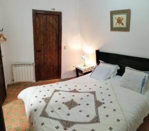 a bedroom with a bed with a quilt on it at Dar Ines in Moulay Idriss Zerhoun