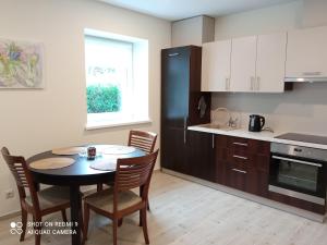 a kitchen with a table and chairs and a black refrigerator at Antonio house in Ramučiai