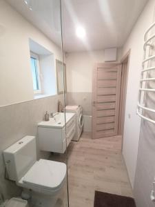 een witte badkamer met een toilet en een wastafel bij Antonio house in Ramučiai
