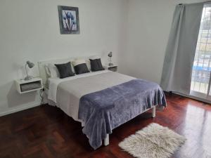 a bedroom with a large bed with a blue blanket at El Palomar Misiones 6574 in El Palomar