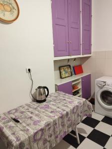 a kitchen with purple cabinets and a table with a tea kettle at Комната pilika 4room with shared bath in Athens