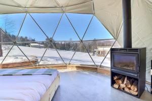 Una habitación con chimenea en una yurta con nieve en mi-clos - luxury pods with private jacuzzis, en Orford