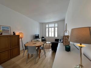 sala de estar con mesa y sofá en Petite maison de charme, en Le Touquet-Paris-Plage