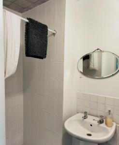 a white bathroom with a sink and a mirror at Brynawel in Aberystwyth