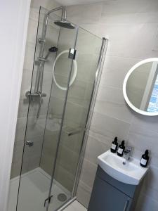 bagno con doccia, lavandino e specchio di 128 Anfield Road a Liverpool