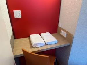a small room with two towels on a shelf at Premiere Classe Blois Nord in Blois +30 photos