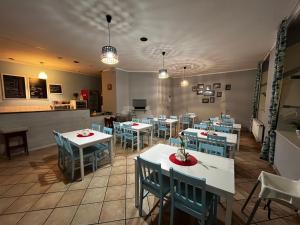 a restaurant with white tables and blue chairs at Apartamenty w Sercu Miasta in Puck