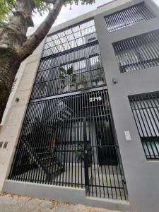 un edificio con cancello e panchine di Departamento estilo minimalista a estrenar a Buenos Aires