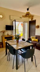 a dining table and chairs in a living room at Lozari Beach in Belgodère