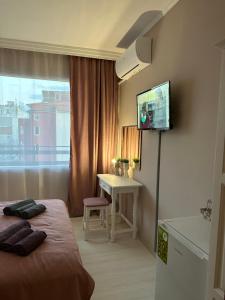 a hotel room with a bed and a desk and a television at Guest house “Poli” in Nesebar